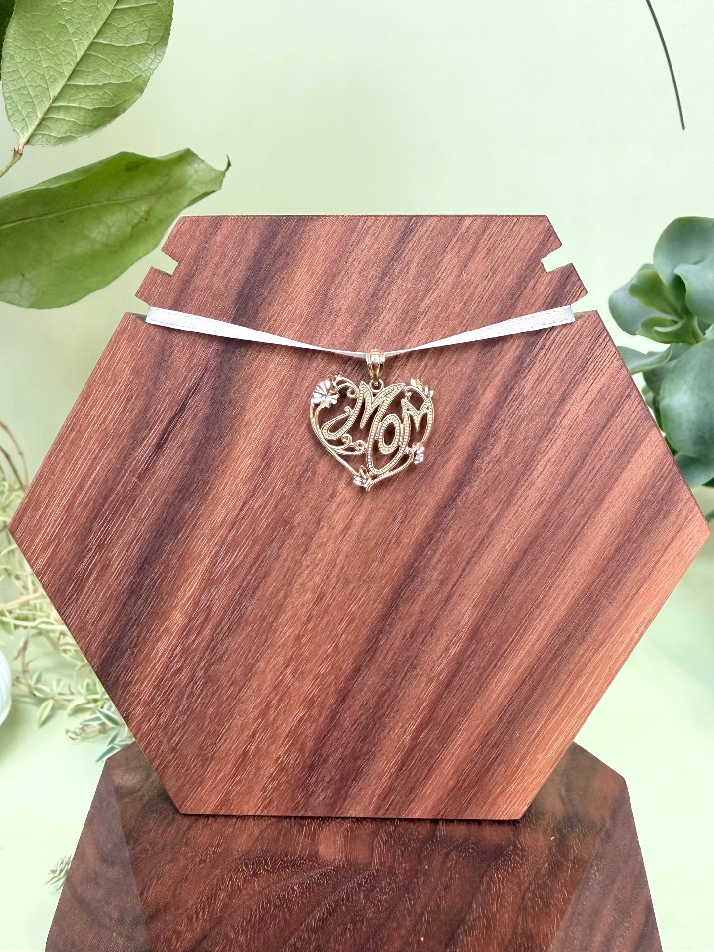 Mom encased in heart with scroll and diamond-cut detailing in 14kt yellow gold, approximately 23mm wide, 20mm long, 1.66g