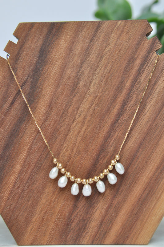 Pearl charm necklace with 7 oval shaped white pearls and 14kt hollow gold beads on 14kt yellow gold chain (some denting on hollow gold beads, some kinks in chain-listed price reflective of notes)