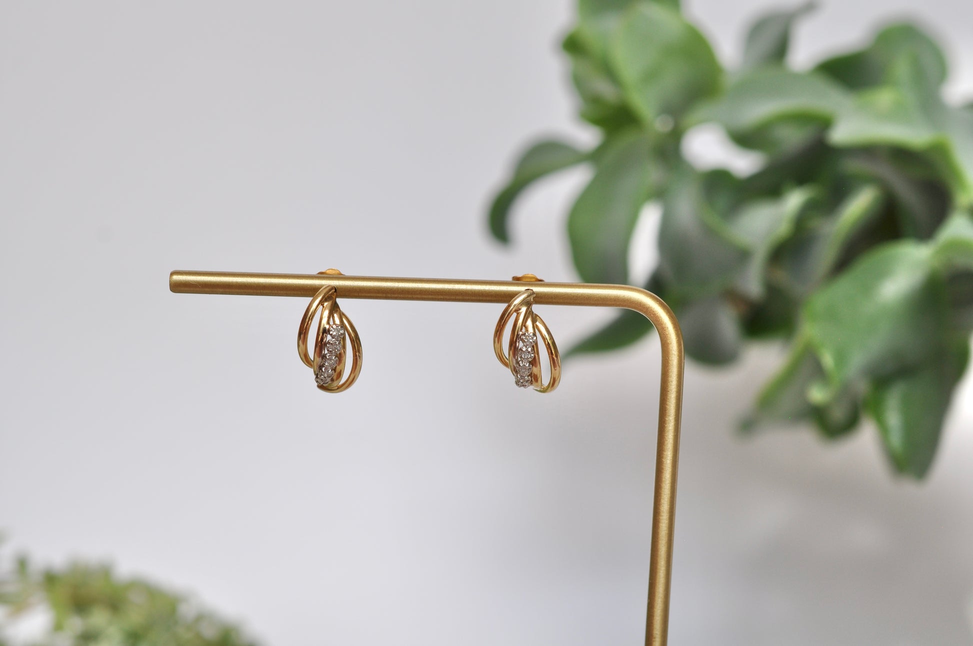 Diamond earrings with curved tube detailing in 14kt yellow gold featuring 5 diamond on each earring (.12ct total weight), stud post earrings