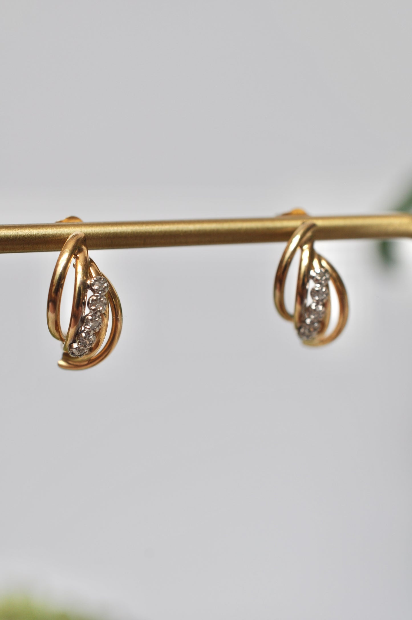 Diamond earrings with curved tube detailing in 14kt yellow gold featuring 5 diamond on each earring (.12ct total weight), stud post earrings