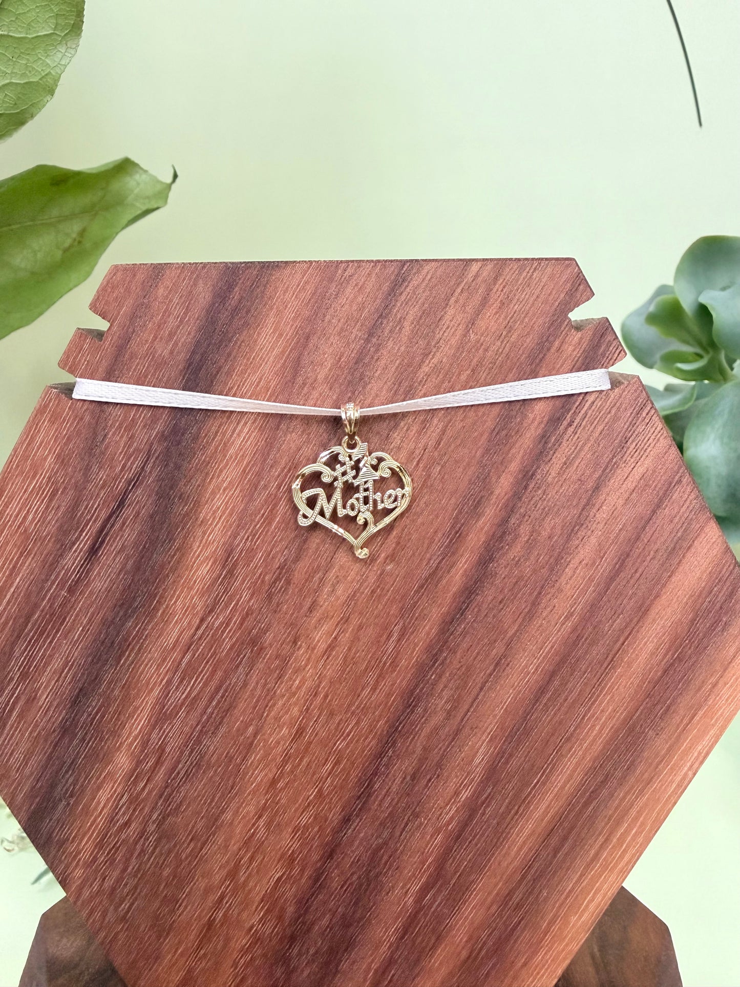 #1 Mother encased in heart with scroll detailing in 14kt yellow gold, approximately 17mm wide, 16mm long, 0.89g